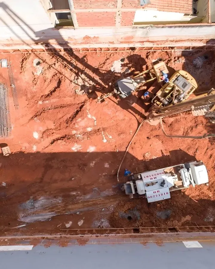 Vista aérea de escavação urbana estreita com contenção nas laterais, executada pela HR Fundações